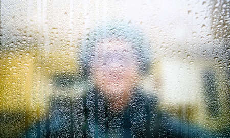 Close up of a man behind the glass with condensation on it