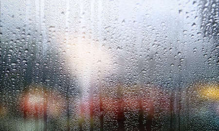 Water drops on the window glass, blurred background. Rainy weather.
