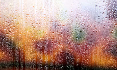 Water drops on window glass, rainy weather background. Close-up view