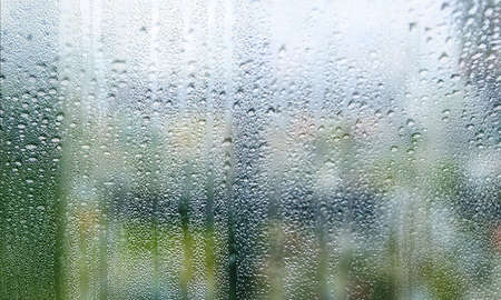 Water drops on window glass. Rain drops on window glass background. Close up view.