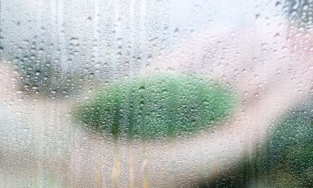 Water drops on window glass, closeup view. Rainy weather