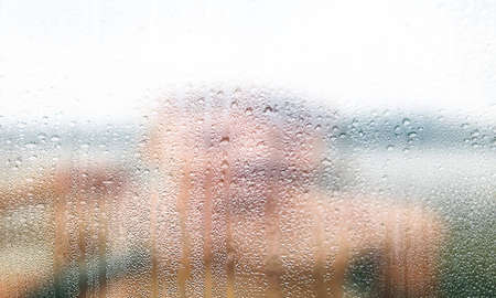 Condensation on the window. Rain drops on the glass. Blurred background.の写真素材