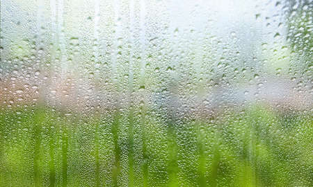Drops of rain on the window, blurred background. Rainy weather.