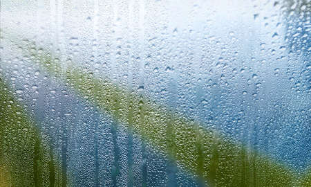 Water drops on window glass close-up. Rainy weather background