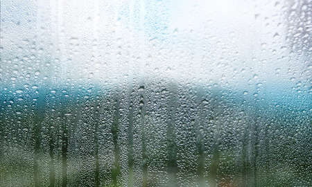 Water drops on window glass, closeup view. Rainy weather