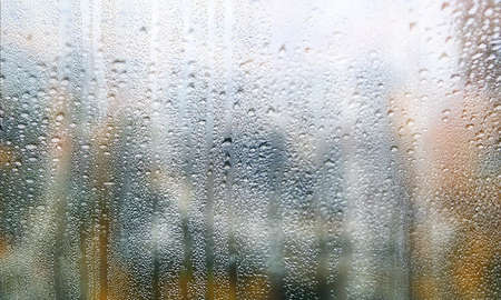 Background with rain drops close up. Rain drops on outdoor window, blurred background with copy...
