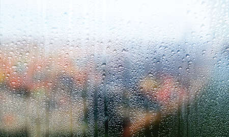 Background with rain drops on glass. Rain drops on outdoor window, closeup view. Wet glass surface,...