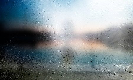 Rain drops on the window glass, blurred background. Close up view.