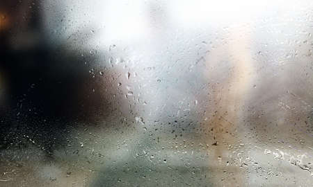 Water drops on the window, blurred background with bokeh effectの写真素材