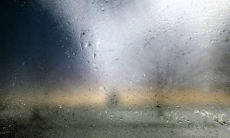 Rain drops on a window glass with a blurred background. Close-up.