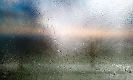 Rain drops on the window glass, close-up, blurred background