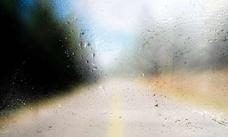 Water drops on the glass with a blurred background of the road.
