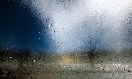 Rain drops on the window with blurred background. Rainy weather.