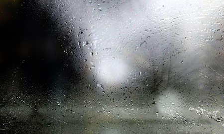 Drops of rain on the window, close-up. Raindrops on the glass, blurred background