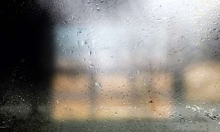 Drops of rain on the window, blurred background with bokehの写真素材