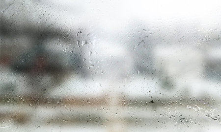 Drops of rain on the window, close-up view. Rain drops on the glass, blurred background with copy...