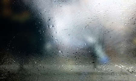 Water drops on glass with blurred background. Rain drops on window surface.