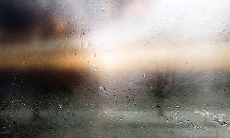 Rain drops on window glass with blurred background. Raindrops on window glass closeup.
