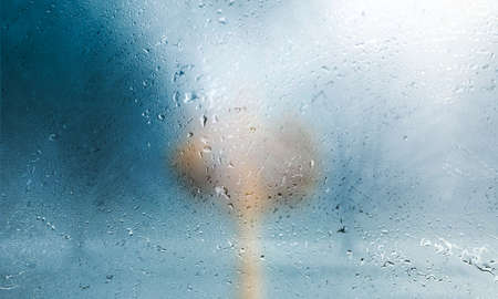 Rain drops on the glass with a blurred background. Abstract background.の写真素材