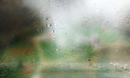 Drops of rain on the glass, blurred background. Rain drops on the window, close-up view.