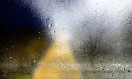 Background with rain drops close up. Rain drops on outdoor window, Closeup view transparent water drops on glass surface, humid water backdrop, blurred background with copy space for your textの写真素材