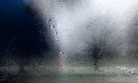Rain drops on window glass with blurred background. Rainy day.