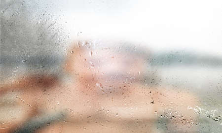 Rain drops on window glass, blurred background with copy space for your textの写真素材