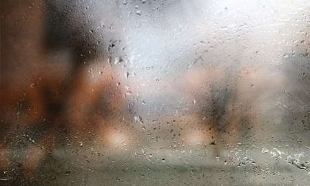 Drops of rain on the window, blurred background. Rainy weather.