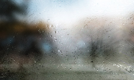 Rain drops on the window with blurred background. Rainy weather.
