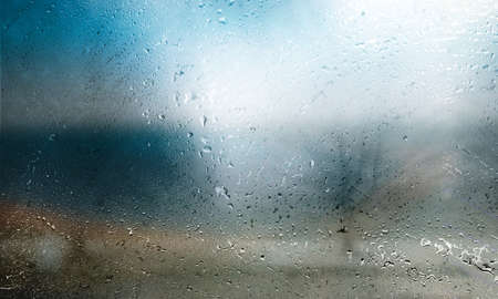 Water drops on the glass, blurred background. Rainy weather concept