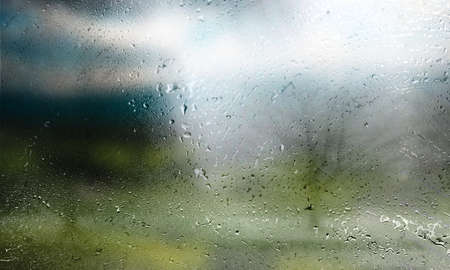 Rain drops on the window glass, blurred background with bokeh