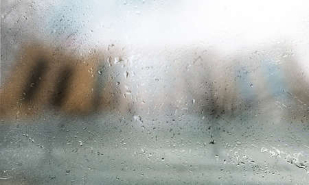 Drops of rain on the glass, blurred background. Rain drops on the window, rainy weather