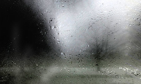 Drops of rain on the window glass, rainy weather background.