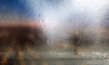 Rain drops on window glass, blurred background. Rainy weather.