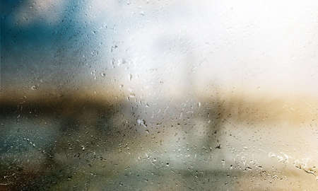 Rain drops on the window glass in a rainy day. Natural background
