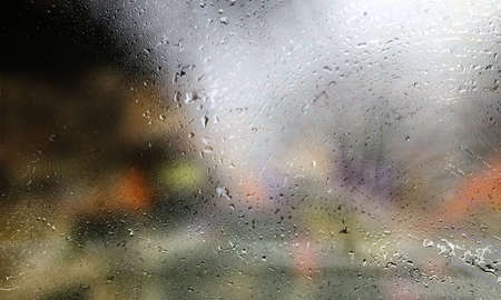 Drops of rain on the glass, blurred background. Rainy weather.