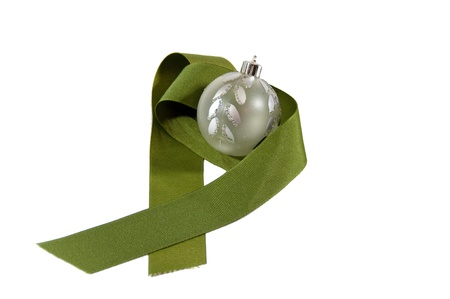 A silver sparkly ornament with a green ribbonの写真素材