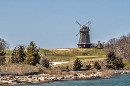 A vintage windmill stands tall above a local golf course.の写真素材