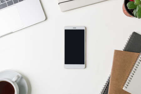 Top view of office workplace. White desk with copy space. Flat lay view on table with laptop,...