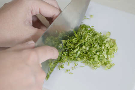 Chopping culantro on plastic blockの写真素材