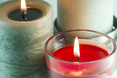 Burning candles, green one and red oneの写真素材