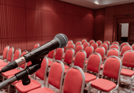 Preparing microphone on podium of conference hall or seminar room event backgroundの写真素材