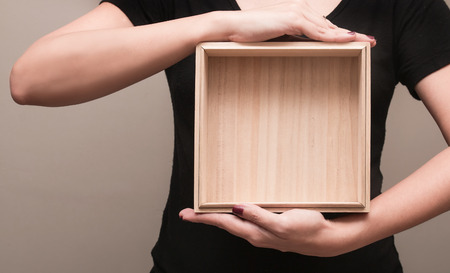 A woman in black T-shirt stood bringing a wooden boxの写真素材