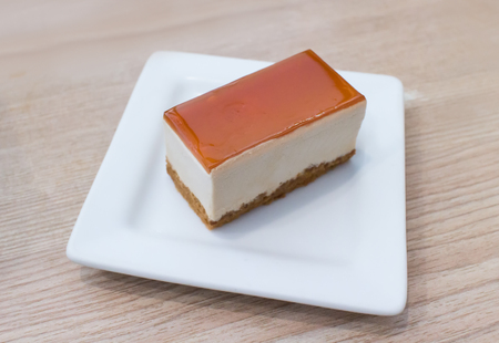 New York cheesecake topping with caramel serving on white plate wooden vintage backgroundの写真素材