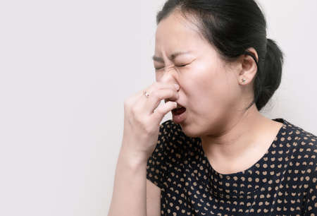 Portrait of Asian woman sneezing from VIRUS COVID-19 or epidemic disease. Health promotion concept.の写真素材