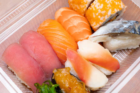 Variety of sushi in plastic box for delivery service. Food delivery concept. Japanese traditional foodの写真素材