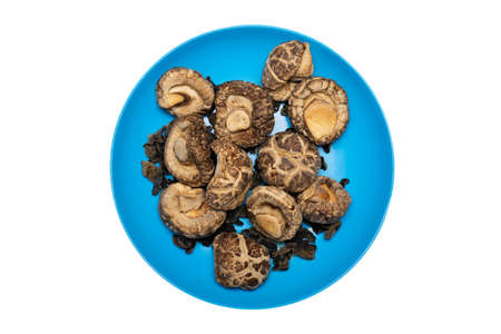 Top view of dried Shiitake Mushroom on blue plate. Isolated on white backgroundの写真素材