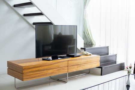 Smart TV wide screen stand on cabinet wooden in the modern living room. Concept of less is more interior designの写真素材