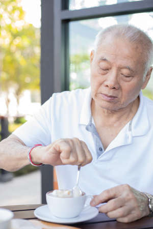 Elderly man drinking coffee outdoor. Healthy senior conceptの写真素材