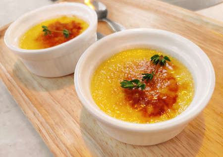 Close up of creme brulee dessert with caramelized sugar on top, on wooden table. Traditional French dessertの写真素材